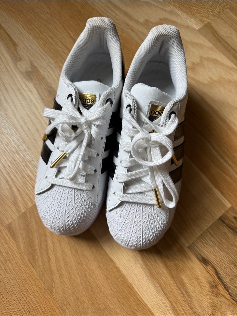 adidas White Sneakers with Black Stripes and Gold Accents